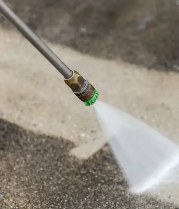 Pressure washing nozzle spraying water on a concrete surface, illustrating professional cleaning services for homes in Gastonia, NC.